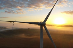 Une photo mettant en avant une éolienne moderne en action sur un paysage ouvert.